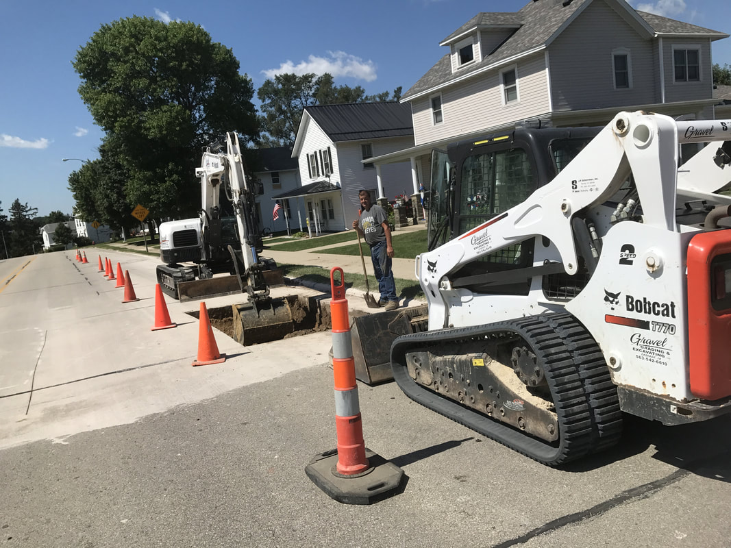 Rick Gravel stops for the camera while working on sewer capping along Main Street in Cascade, IA.